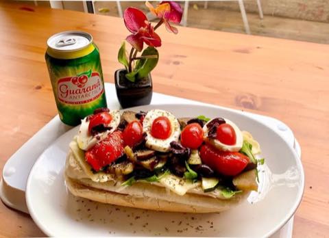 An open sandwich with tomatoes, olives and a poached egg
